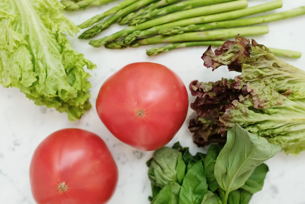 Eine große Schüssel mit buntem Salat aus Gartengemüse, Tomaten und Kräutern.