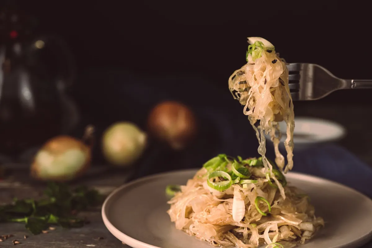 Gebratener Spitzkohl mit Gewürzen in einer dunklen Pfanne angerichtet.