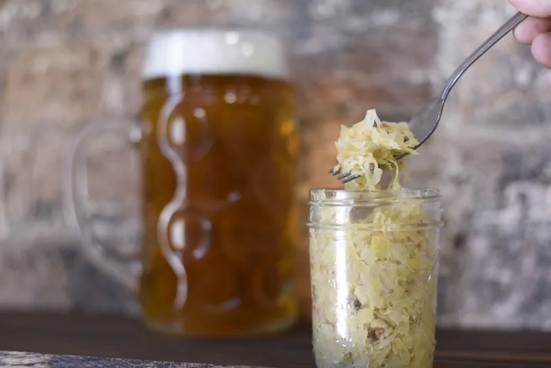 Selbstgemachtes Sauerkraut in einem rustikalen Einmachglas auf einem Holztisch.