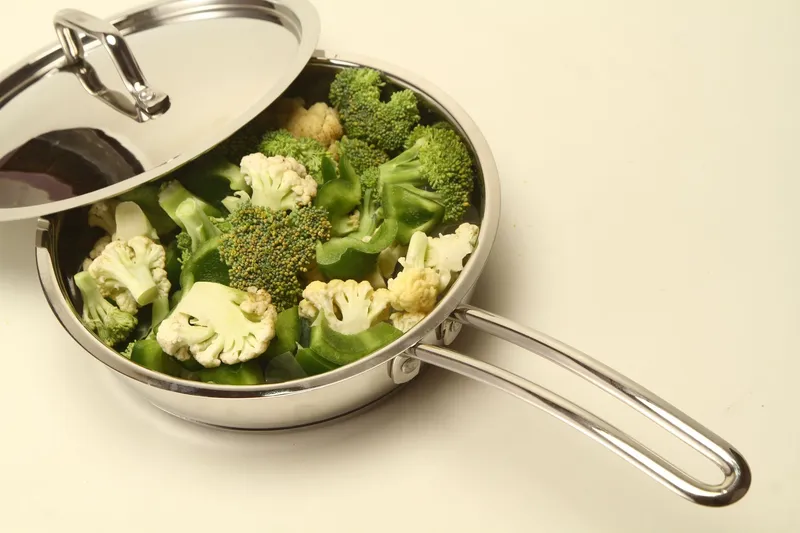 Frisches Gemüse in einer Edelstahlpfanne, bereit zum Kochen.
